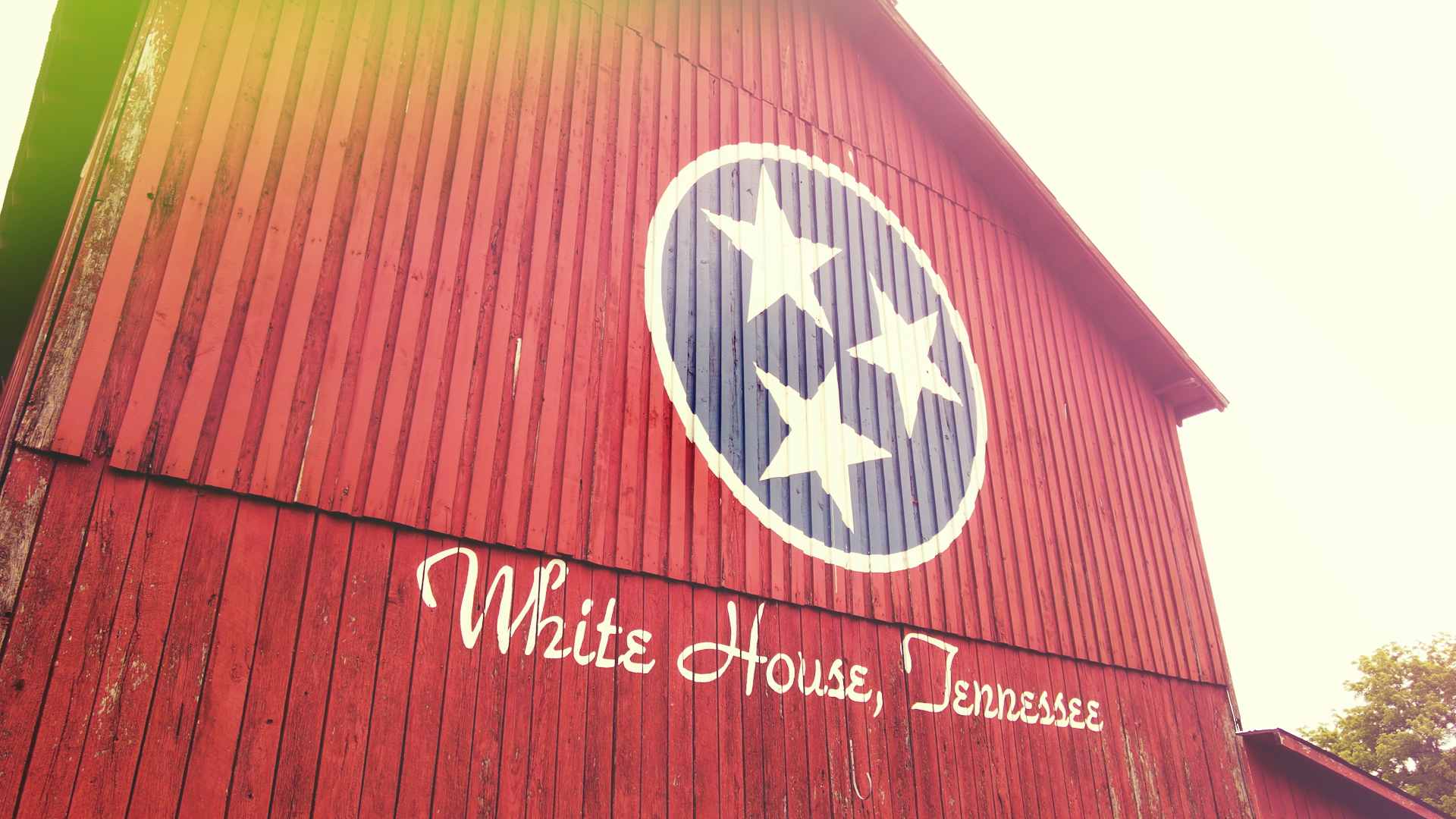 Barn painted with Tennessee Flac colors and symybols, with writing that reads Barn painted with Tennessee Flac colors and symybols, with writing that reads