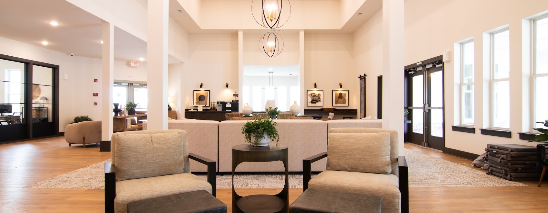 Modern clubhouse lounge at Sage North apartments in White House, TN, featuring stylish seating, high ceilings, a coffee bar, and natural light-filled spaces for residents to relax and connect.