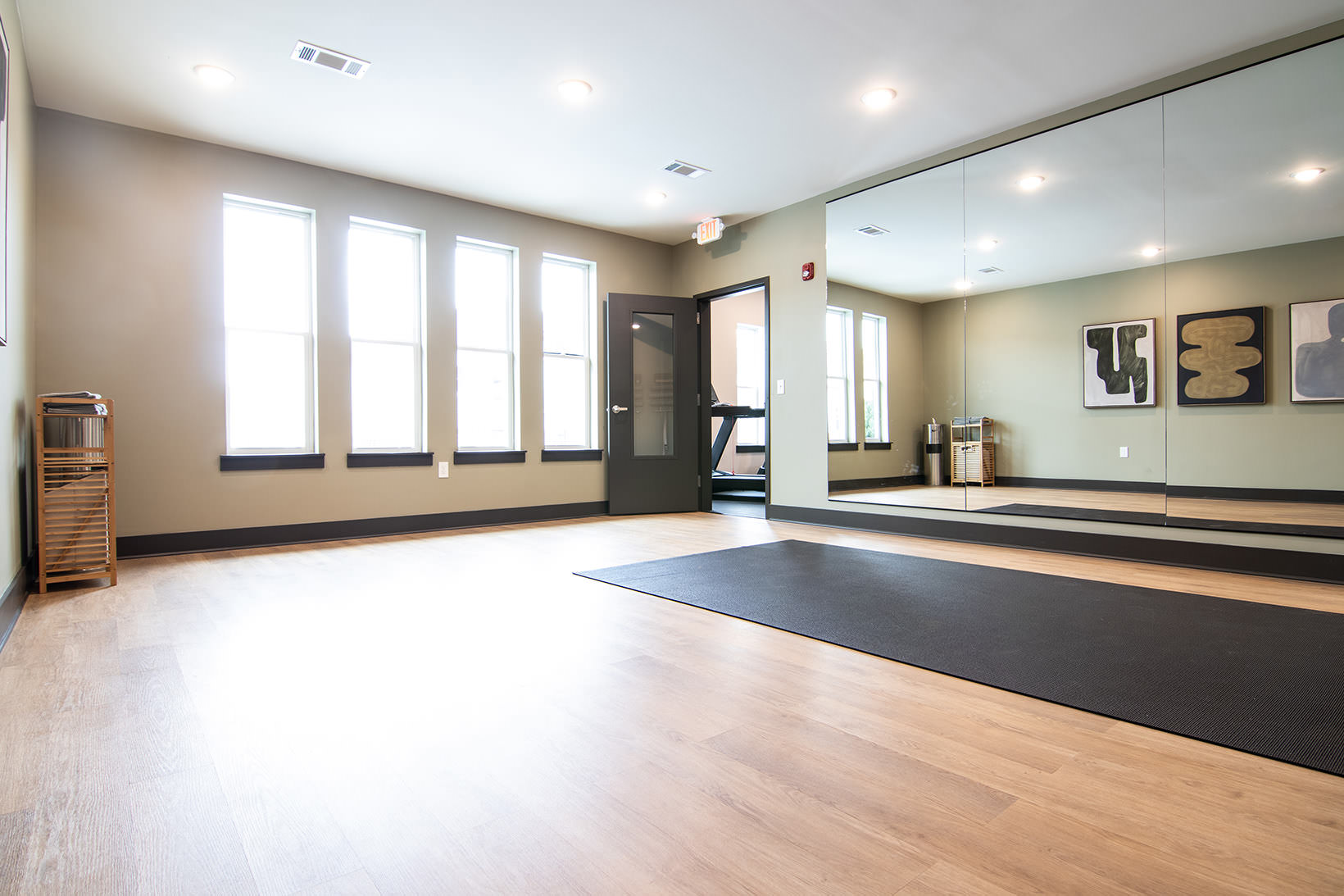 Yoga studio with mirror wall and bright windows at Sage North apartments in White House, TN.